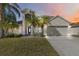 Charming two-story home featuring a neutral color palette, two-car garage, and lush tropical landscaping at 965 Rosinia Ct, Orlando, FL 32828