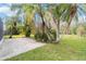 Lush tropical landscaping surrounds the property with a concrete side driveway at 965 Rosinia Ct, Orlando, FL 32828