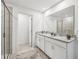 Well-lit bathroom featuring a dual sink vanity with granite counters and a walk-in shower at 1136 Clay Blvd, Tavares, FL 32778