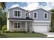 Charming two-story home featuring stone accents, shaker siding, a covered entry, and an attached two-car garage at 1136 Clay Blvd, Tavares, FL 32778