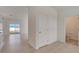 Hallway with neutral tile flooring, a half bathroom and a view of the living room and back yard at 1136 Clay Blvd, Tavares, FL 32778