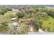 Aerial view showcasing a house with outbuildings, all nestled amongst mature trees in a tranquil neighborhood setting at 119 E Central Ave, Bushnell, FL 33513