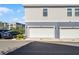 Modern home featuring a two-car garage with a clean, white door and sleek exterior lighting at 1194 Spotted Sandpiper Loop, Winter Springs, FL 32708