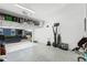 Spacious garage with ample storage, an open door leading to a blue sky view, and workout equipment at 1194 Spotted Sandpiper Loop, Winter Springs, FL 32708