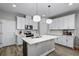 Modern kitchen features white cabinets, stainless steel appliances, and a center island at 1194 Spotted Sandpiper Loop, Winter Springs, FL 32708