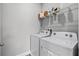 Functional laundry room with a modern washer and dryer set and overhead shelving for storage at 1194 Spotted Sandpiper Loop, Winter Springs, FL 32708