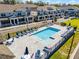 Community pool surrounded by seating and umbrellas, perfect for leisure, nestled within a neighborhood at 1194 Spotted Sandpiper Loop, Winter Springs, FL 32708