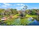 Scenic aerial view of a lakeside property featuring a private dock and lush green surroundings at 12002 Mckinnon Rd, Windermere, FL 34786