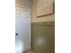 Hallway with beadboard accent wall, a decorative art piece, and a white six panel door at 12853 Maryland Woods Ct, Orlando, FL 32824