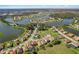 A high angle aerial view of a home in a lakeside community with manicured lawns, trees, and a playground at 1330 Bucktail Ct, Kissimmee, FL 34746