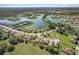 A high angle aerial view of a home in a lakeside community with manicured lawns, trees, and a playground at 1330 Bucktail Ct, Kissimmee, FL 34746