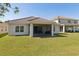 Lush backyard featuring a covered patio with outdoor furniture and a well-maintained lawn at 1330 Bucktail Ct, Kissimmee, FL 34746