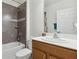 Full bathroom boasts modern fixtures, gray tiling and a convenient shower and bathtub combo at 1330 Bucktail Ct, Kissimmee, FL 34746