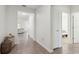 Bright hallway featuring neutral tile flooring, white walls, and doorways leading to other rooms at 1330 Bucktail Ct, Kissimmee, FL 34746