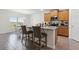 Open kitchen features a central island with barstool seating, granite counters, and views into the dining area at 1330 Bucktail Ct, Kissimmee, FL 34746
