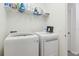 Bright laundry room with a white washer and dryer, wire shelving, and easy access to the rest of the home at 1330 Bucktail Ct, Kissimmee, FL 34746