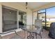 Covered patio with comfortable seating, a table, and a view into the spacious living room through a glass sliding door at 1330 Bucktail Ct, Kissimmee, FL 34746