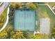 Aerial view of tennis and basketball courts surrounded by mature trees at 1330 Bucktail Ct, Kissimmee, FL 34746