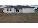 Newly constructed home features a backyard, patio with sliding glass doors, and black roof at 13566 Sw 43Rd Cir, Ocala, FL 34473