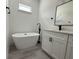 A bathroom featuring a standalone tub, a sleek black faucet, and a modern white vanity at 13566 Sw 43Rd Cir, Ocala, FL 34473