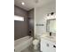 Updated bathroom featuring a gray tiled shower and a vanity with modern lighting at 13566 Sw 43Rd Cir, Ocala, FL 34473