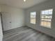 Light-filled bedroom with sleek gray flooring and dual windows, providing a bright and airy feel at 13566 Sw 43Rd Cir, Ocala, FL 34473
