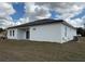 Side angle view of white home showcasing windows, black roof, and AC unit at 13566 Sw 43Rd Cir, Ocala, FL 34473