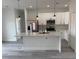 This bright kitchen features white cabinets, a stainless steel refrigerator, pendant lighting, and a breakfast bar at 13566 Sw 43Rd Cir, Ocala, FL 34473
