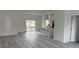An open-concept living room with light gray flooring, white walls, and a view of the kitchen at 13566 Sw 43Rd Cir, Ocala, FL 34473