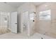 Bathroom featuring a tiled shower, modern fixtures, white doors, and tile flooring, creating a clean and stylish space at 13592 Sw 43Rd Cir, Ocala, FL 34473