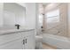 Modern bathroom with marble wall paneling, bathtub, shower head, and vanity with black accents. A bright and stylish design at 13592 Sw 43Rd Cir, Ocala, FL 34473