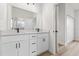 Elegant bathroom with double vanity, white cabinets, quartz countertop, large mirror, and modern lighting fixtures at 13592 Sw 43Rd Cir, Ocala, FL 34473