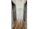 Hallway with wood flooring, white walls, and natural light streaming in from the bedroom windows at the end at 13592 Sw 43Rd Cir, Ocala, FL 34473
