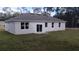 Backyard view of home with a large grassy area, modern windows, and a sliding glass door at 1385 5Th St, Orange City, FL 32763