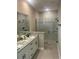 Bathroom with a glass shower enclosure, granite countertops, and dual sink vanity at 1385 5Th St, Orange City, FL 32763