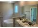 Bathroom featuring double sinks with granite countertops and a large bathtub at 1385 5Th St, Orange City, FL 32763