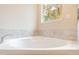 Close-up of a pristine white bathtub with tiled surround and a view from the window at 1385 5Th St, Orange City, FL 32763