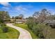 Aerial view of a well-maintained home with a long driveway and lush landscaping at 1581 Monica Joy Cir, Longwood, FL 32779