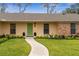 Charming entryway featuring a bright green door, brick accents, manicured shrubs and a paved walkway at 1581 Monica Joy Cir, Longwood, FL 32779