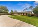 View of single story home with a large green front yard with mature landscaping and a curved walkway at 1581 Monica Joy Cir, Longwood, FL 32779