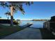 Scenic lake view with a boat dock, grassy lawn, and mature trees lining the shore at 1581 Monica Joy Cir, Longwood, FL 32779