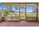 A screened in patio with brick floors provides ample space for entertaining, with a lush green lawn and trees in the background at 1581 Monica Joy Cir, Longwood, FL 32779