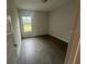 A bright bedroom featuring wood-look tile floor, natural light, and neutral paint at 17792 Adrift Rd, Winter Garden, FL 34787