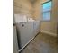 Laundry room with washer, dryer, wire shelving, and window at 17792 Adrift Rd, Winter Garden, FL 34787