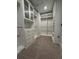 Spacious walk-in closet with custom shelving, drawers, and carpet flooring at 17792 Adrift Rd, Winter Garden, FL 34787