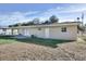 Home's backyard features a covered patio, a sliding glass door, and a well-maintained lawn at 1797 31St Nw St, Winter Haven, FL 33881