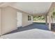 A covered carport showing a concrete foundation, a white exterior door, and a view of the yard beyond at 1797 31St Nw St, Winter Haven, FL 33881