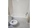 Clean bathroom featuring white tub and toilet, complemented by classic black and white tile flooring at 2019 Dixie Belle Dr # 2019O, Orlando, FL 32812