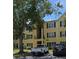 Condominium building with yellow siding, black shutters, and mature landscaping at 2019 Dixie Belle Dr # 2019O, Orlando, FL 32812