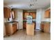 Well-lit kitchen with central island, stainless appliances, tile floors and granite countertops at 2143 Tealwood Cir, Tavares, FL 32778